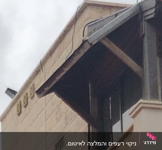 גג עם מרזב מתכת וכבלים חשמליים